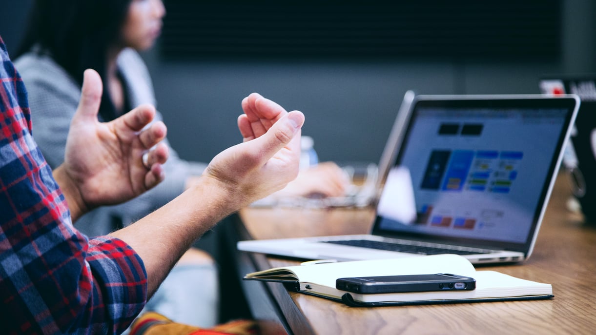 A man in front of a laptop in a meeting