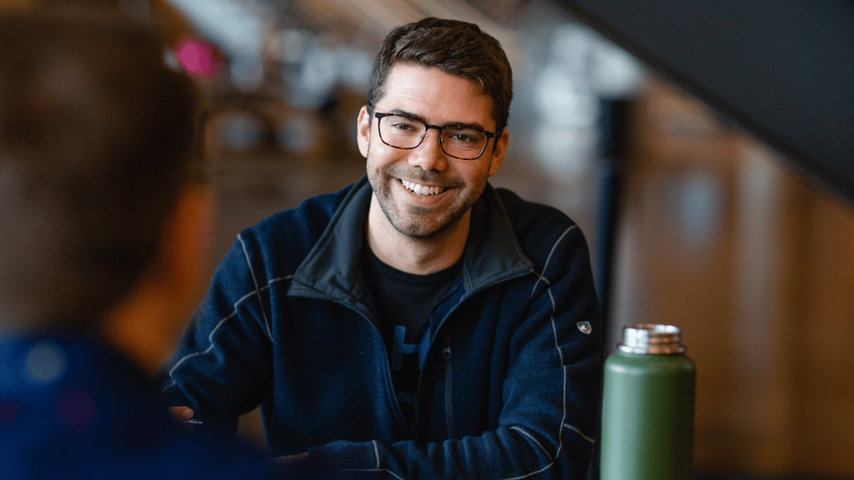 Man smiling at a table