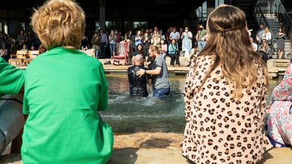 A man getting baptized surrounded by friends