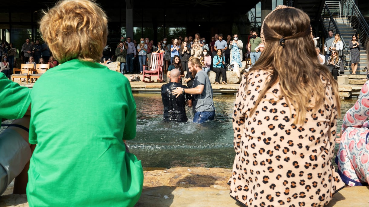 A man getting baptized surrounded by friends
