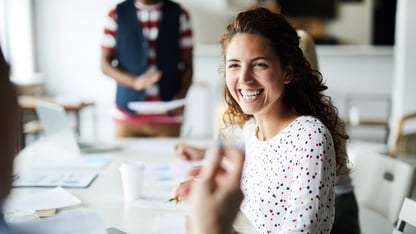 A woman sits in a work meeting