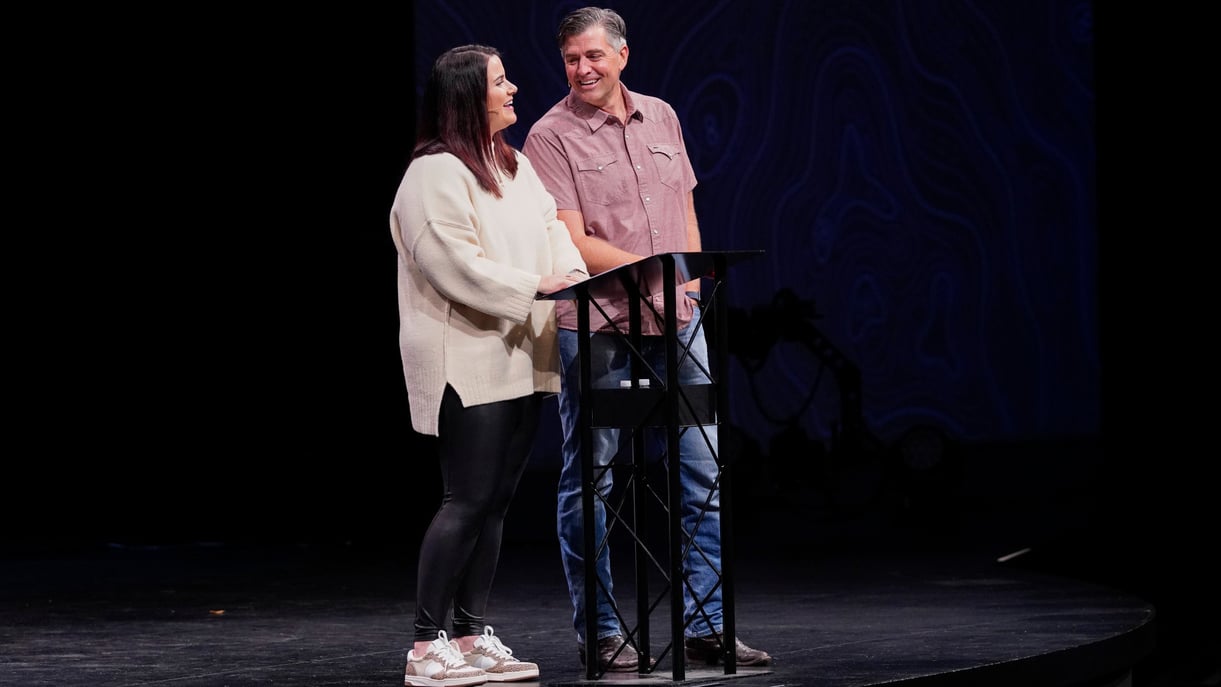 A couple speaks from a stage