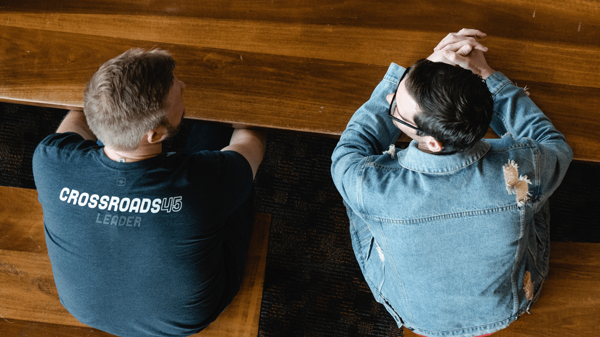 2 men sitting in a church pew