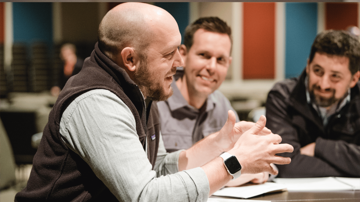 A group of men sitting together in a meeting