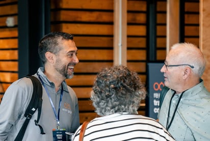 Re|engage Marriage Ministry Open House photos of ministry leader and church leader couple in front of a natural wood colored horizontal slatted wall at Watermark Community Church in Dallas, TX.
