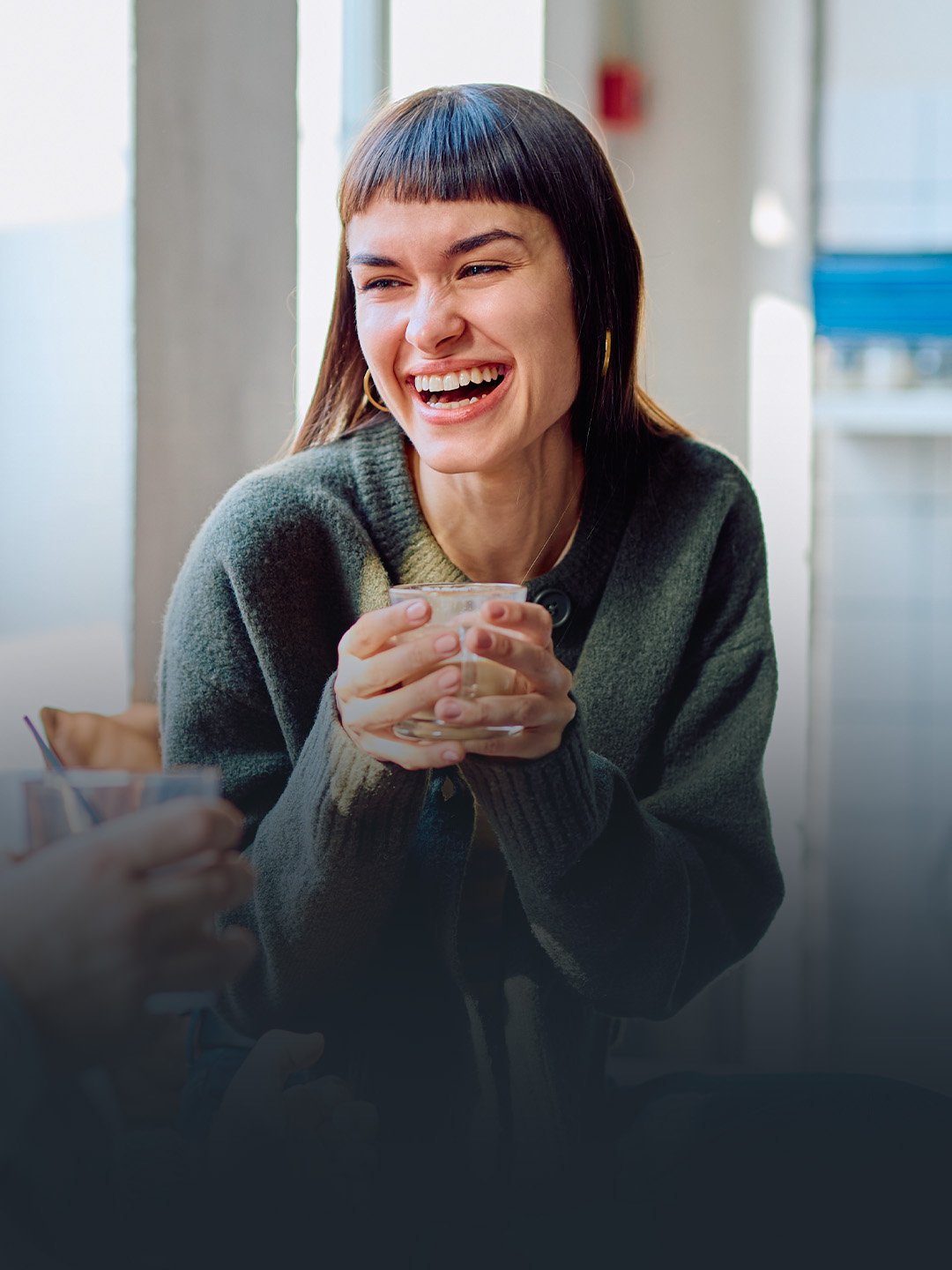A Christian woman sipping coffee and laughing