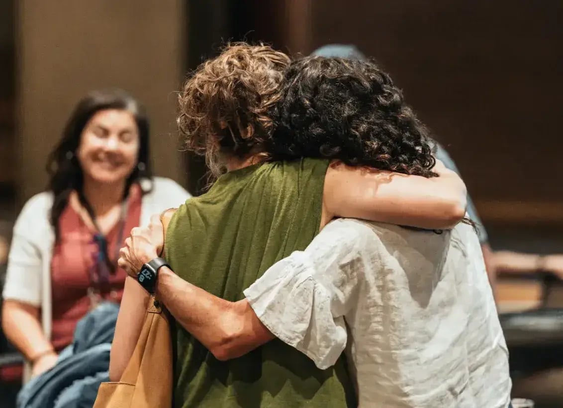 Two women hugging at a conference