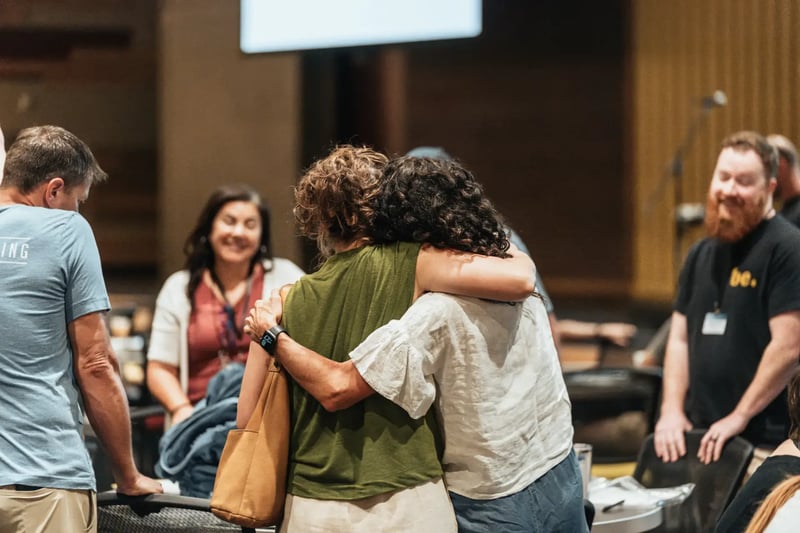 Two women hugging at a Watermark training conference