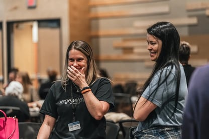 Two women laughing together at an event