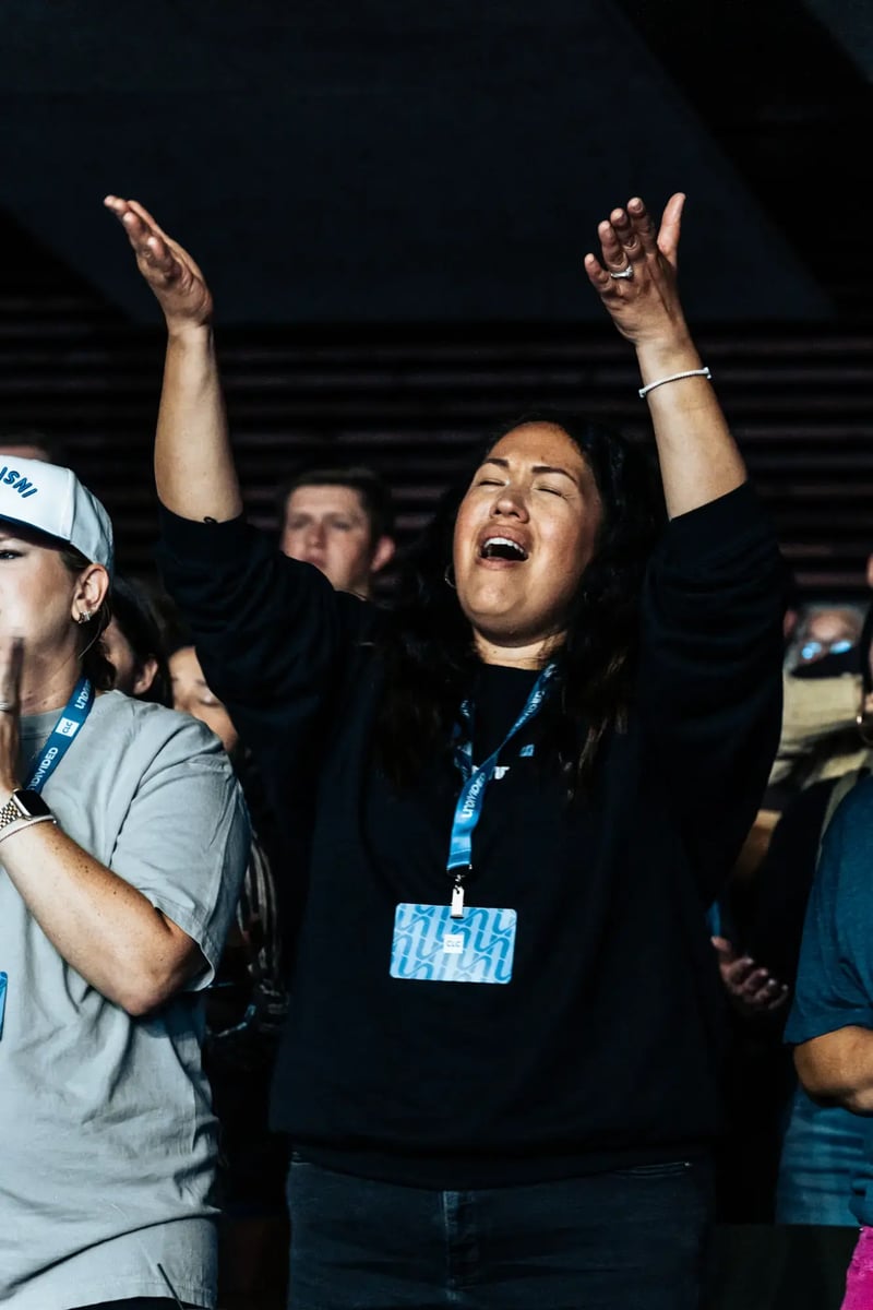 CLC woman attendee worshiping with arms raised