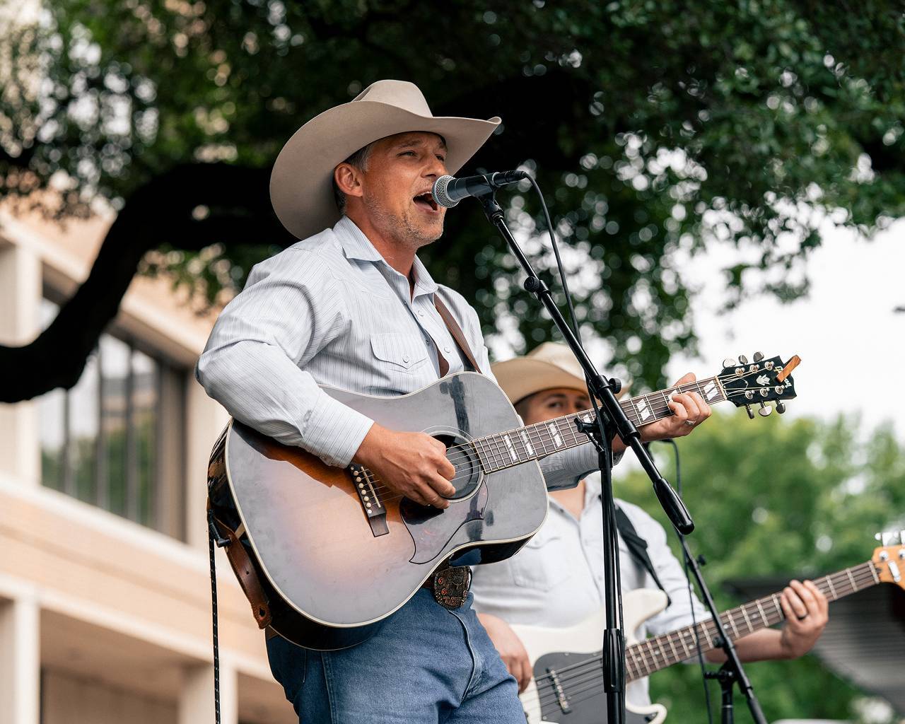 Man in cowboy hat singing with a guitar
